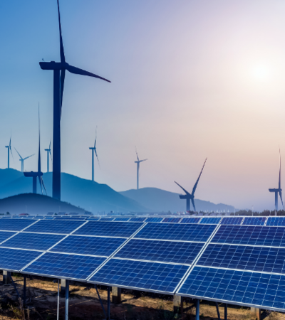 Solar panels and wind turbines generating renewable energy under a sunset sky